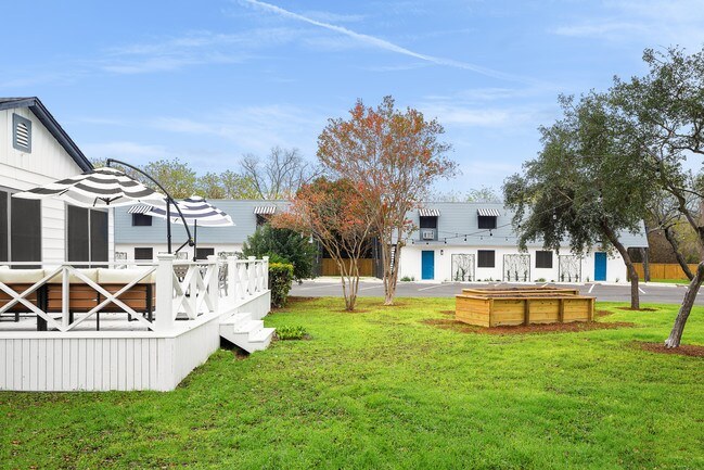 A white house with a deck and a blue door.